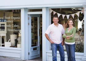 Couples Standing In Front Of Organic Food Store Smiling