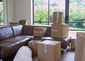 View of packed cardboard boxes in living room of a new home